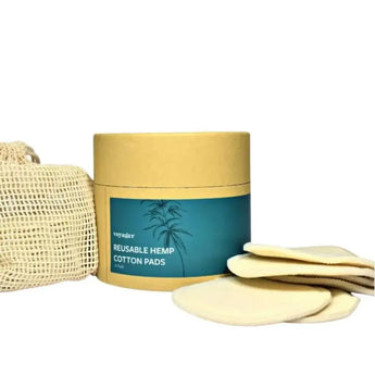 A circular brown cardboard box with a lid, containing reusable hemp cleansing pads, set against a white background