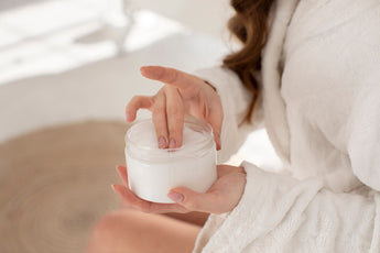 Lady holding a moisturing cream showing that beauty and skin health can be maintained by using beauty products and CBD creams