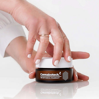 woman opening jar of antioxidant face cream